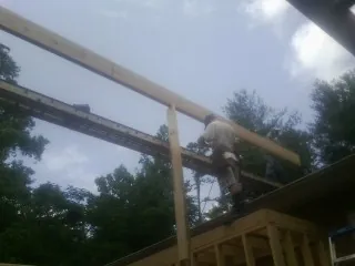 Carpenter setting a ridge beam over a new addition frame — Ice Dam Removal by Roofing Brothers in Camano Island