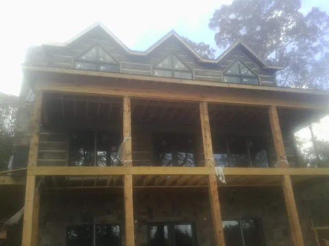 Dormers and porch framing on a large log home under construction — Roof Coating work by our crew in Camano Island